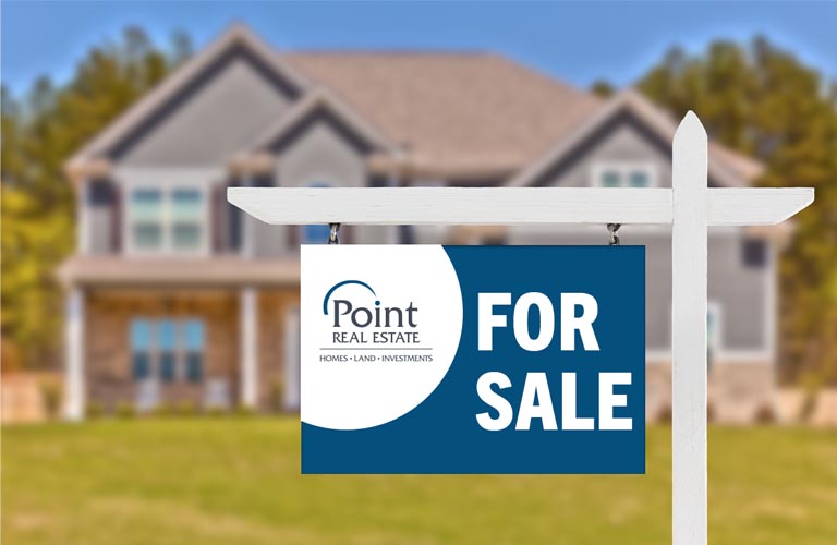 Point Real Estate for sale sign in front of a new home